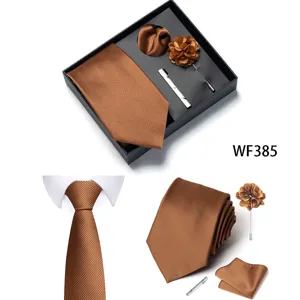 Vista dettagliata degli accessori per cravatta da uomo marrone con fazzoletto e fiore da risvolto.