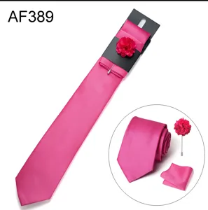 Vista dettagliata del set cravatta rosa vivo con jacquard, fiore da risvolto e pochette.