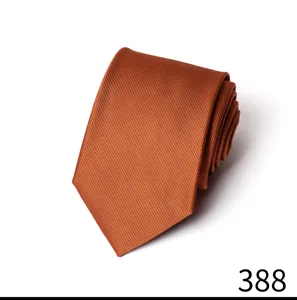 Nahaufnahme einer gerollten orange-braunen Krawatte mit feinem Twill-Strukturdetail.
