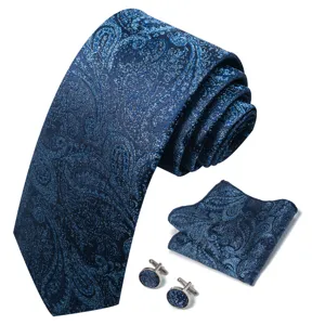 Gedetailleerd overzicht van klassieke blauwe paisley stropdas, pochet en metalen manchetknopen.