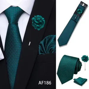 Detail of men green jacquard tie set featuring pointed tie, pocket square, and brooch.