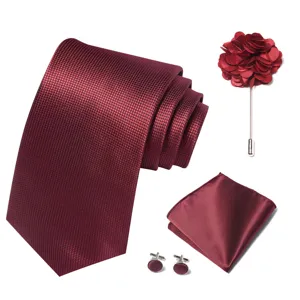 Vista detallada del conjunto de accesorios para hombre en color burdeos con corbata y artículos coordinados.