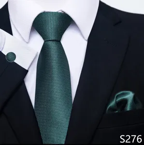 Detailopname van een donkergroene jacquard herendas met pochette en bijpassende manchetknopen.