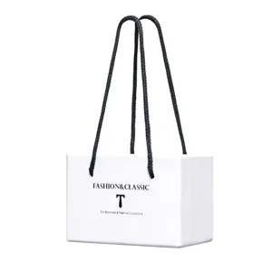 Gedetailleerd uitzicht op witte premium geschenkverpakking met zwarte touwhandvatten.