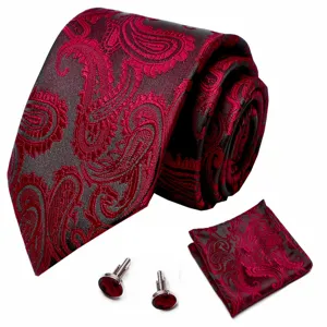 Detailopname van de luxueuze rood-zwarte paisley stropdas, pochet en manchetknopen set.