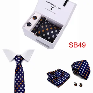 Close-up details of the navy blue polka dot tie, pocket square, and metallic cufflinks set.