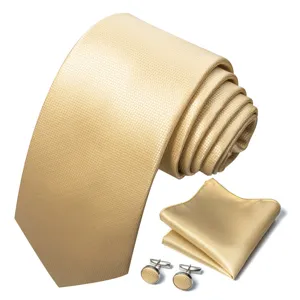 Gouden jacquard stropdas, pochet en manchetknopen detail met fijne stoftextuur.