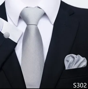 Gedetailleerd overzicht van grijze jacquard das, pochet en manchetknopen voor heren.