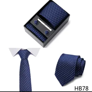 Coffret cravate homme bleu àpois, pochette, boutons de manchette et pince cravate détail.