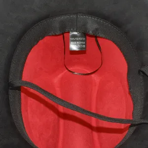 Interior detail of black cowboy hat with red lining, polyester tag and drawstring