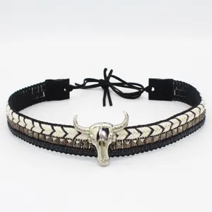 Western cowboy hat band detail, black and white braided rope with silver bull skull pendant.