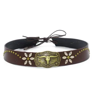 Close-up detail of western cowboy hat band with metal bull skull buckle and flower studs.