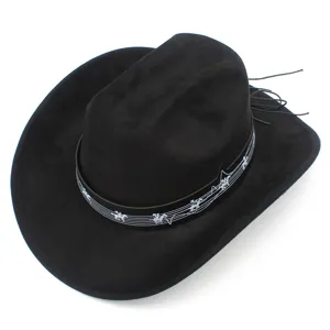 Détail de chapeau de cowboy en suédine noire, style festival de musique avec bande et pompons.