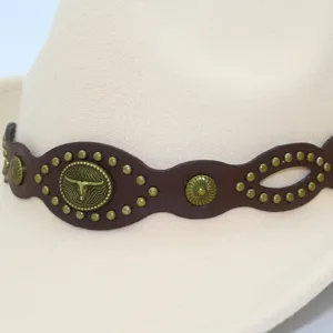 Close up view of beige fedora cowboy hat with brown leather band and bull head emblem.