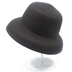 Dettaglio in primo piano del cappello di paglia nera intrecciata con trama fine e tesa.