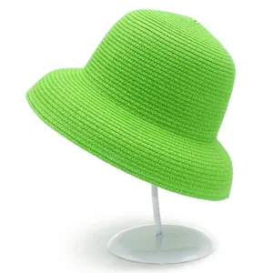 Primo piano dettagliato del cappello da sole intrecciato verde brillante con trama di paglia fine.