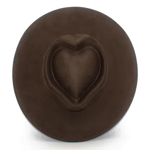 Gros plan sur le chapeau marron à calotte en cœur et large bord, texture suédine douce.