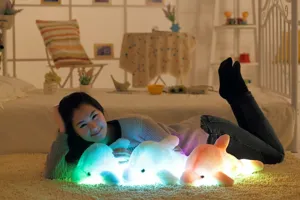 Dettaglio di peluche delfino luminoso in accogliente camera da letto con luci colorate.