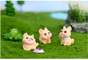 Dettaglio in primo piano di simpatiche statuine di cani in resina in un paesaggio di muschio.