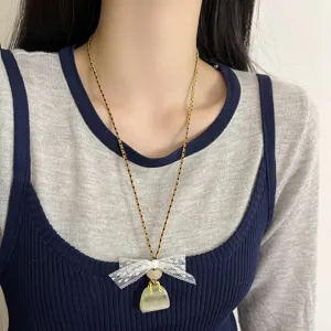 Detail view of the elegant lace bow handbag pendant necklace, featuring the delicate braided cord.