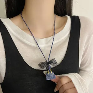 Chic blue stone handbag pendant necklace featuring black lace bow and braided cord for women.