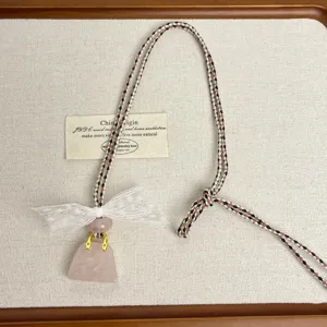 Cute rose quartz bag pendant necklace with white lace bow and braided cord for women.