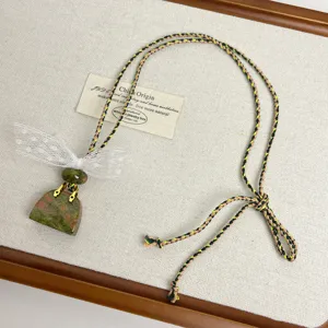 Handmade stone handbag pendant necklace with white lace bow and braided cord detail