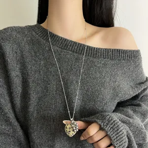 Detail shot of long chain necklace with natural stone heart pendant and cute metal grape charm.