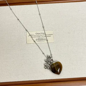 Close-up of the natural stone heart pendant necklace with delicate chain details and beads.