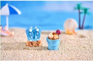 Detalle de adorno en miniatura de playa mediterranea con chanclas y cubo de arena.