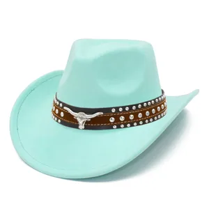 Close-up of mint green suede cowboy hat featuring studded leather band and bull skull emblem.