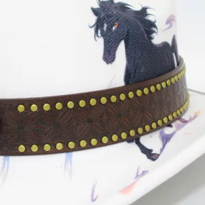 Close-up detail of white fedora hat with black horse print and studded leather band