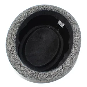 Detailed view of classic plaid fedora hat interior showing size and material label inside.