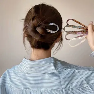 Elegant U-shaped hair stick detail view, showing exquisite tortoise shell patterns and stylish bun.