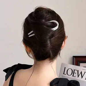 Detailed view of white minimalist U-shaped hair fork styling elegant bun for daily wear.