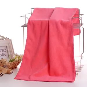 Pink microfiber towel hanging on metal rack with cute props, soft and absorbent fabric.