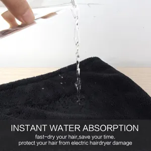 Close-up of black coral fleece hair drying towel showing instant water absorption effect.