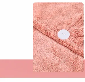 Coral velvet dry hair cap with soft fabric and white button for quick water absorption.