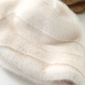 Close-up view of the plush bucket hat showing soft faux fur texture and elegant folds in beige.