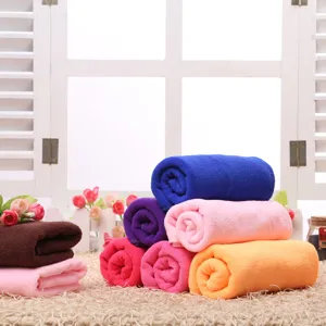 Detailed shot of colorful rolled microfiber towels placed on a decorative straw mat with window.