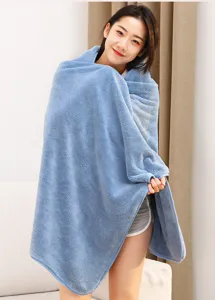 Detailed shot of the soft blue coral fleece bath towel draped over a model indoors.