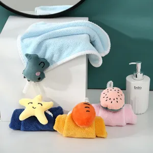 Coral fleece hand towel with cute plush cartoon toy, highly absorbent hanging towel detail.