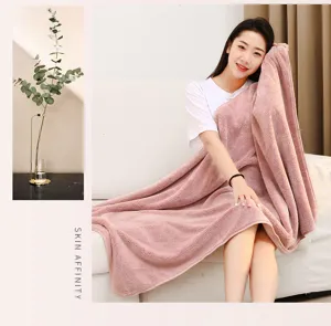 Soft coral fleece blanket detail showing plush texture and comfortable drape in warm home.