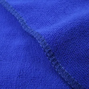 Microfiber towel detail close-up showing soft blue plush fabric texture and neat stitched edge.