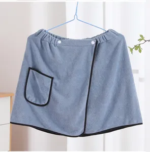 Close-up detail of wearable bath towel wrap with pocket and snap buttons in soft blue fabric.