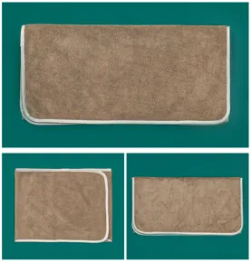 Brown beauty salon towel detail view with white binding edge showing soft folded textile quality.