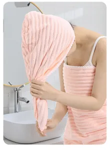 Détail de bonnet de bain et serviette éponge en corail avec texture rayée douce et haute absorption.
