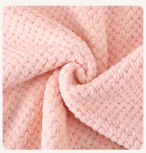 Close-up detail of soft pink coral fleece dry hair cap fabric, showing plush texture.
