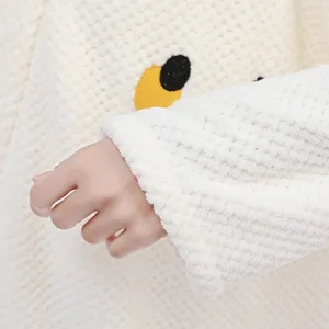 Detailed view of white fluffy waffle fleece bathrobe sleeve with cute embroidered animal accent.