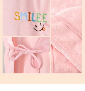Detailed view of pink coral fleece bath robe, showcasing soft texture, embroidery and ties.